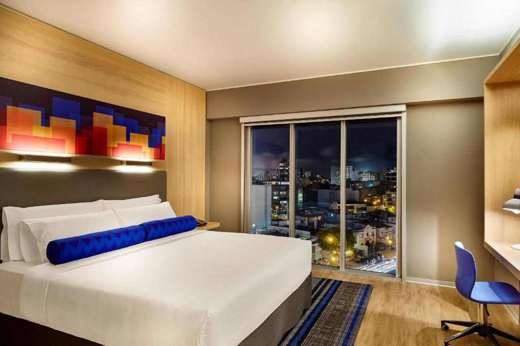 利马Aloft Lima Miraflores的一间卧室设有一张大床和一个大窗户