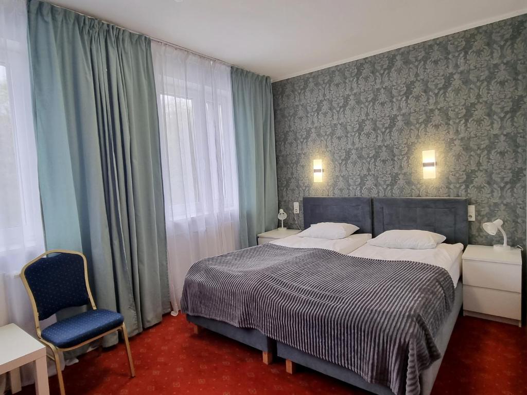 弗罗茨瓦夫欧比特酒店 的一间卧室配有一张大床和一张蓝色椅子