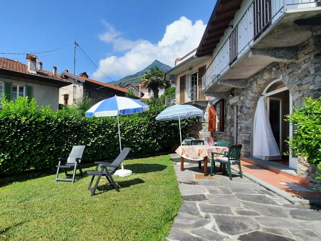 卡尼洛瑞维拉Appartamento Porto 1的庭院配有桌椅和遮阳伞。