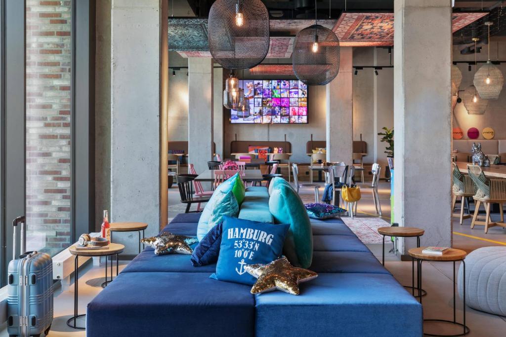 汉堡Moxy Hamburg City的一组蓝色枕头在餐厅的沙发上