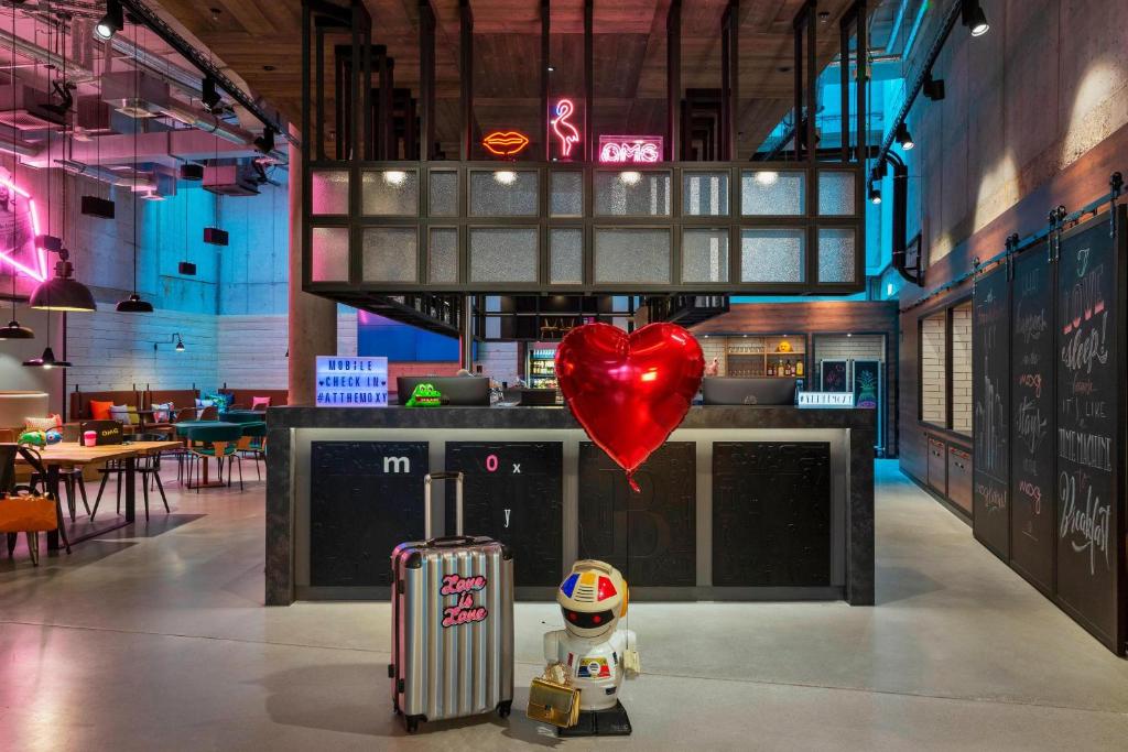 美因河畔法兰克福Moxy Frankfurt City Center的餐厅里有一个心脏气球和一个玩具,还有一只手提箱