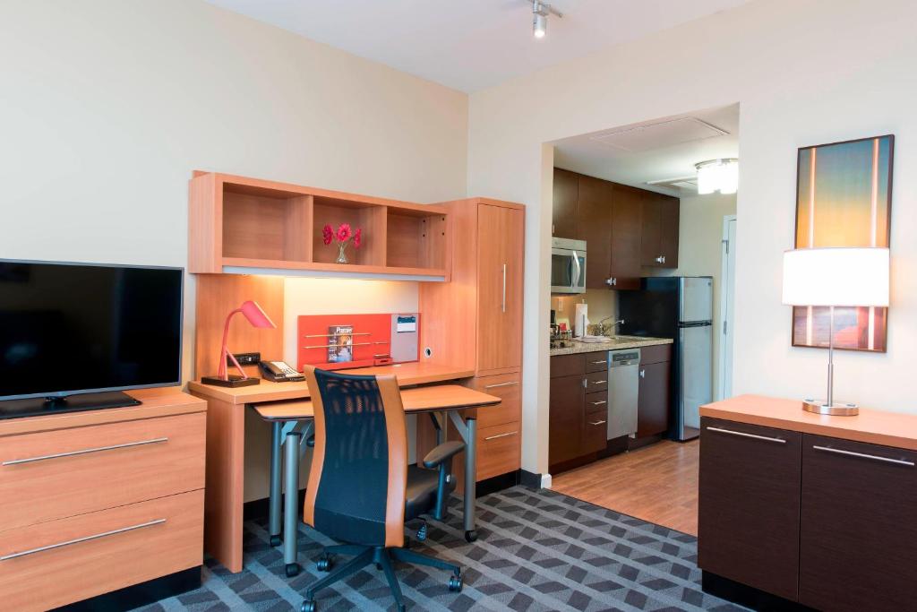 尚佩恩万豪香槟广场套房酒店的厨房配有书桌、电视和桌椅