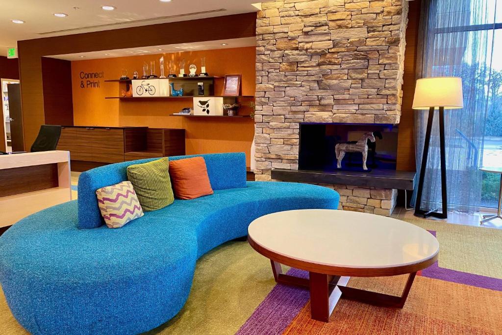 达尔斯Fairfield by Marriott The Dalles的客厅设有蓝色沙发,配有壁炉