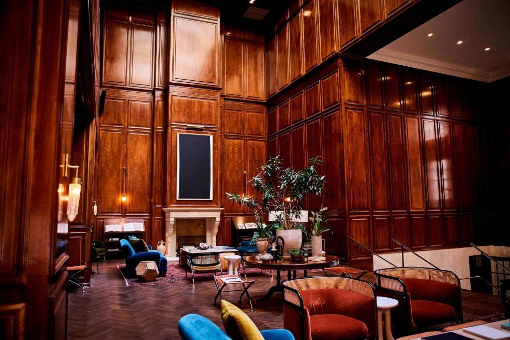 达拉斯阿道弗斯酒店的客厅设有木墙和桌椅