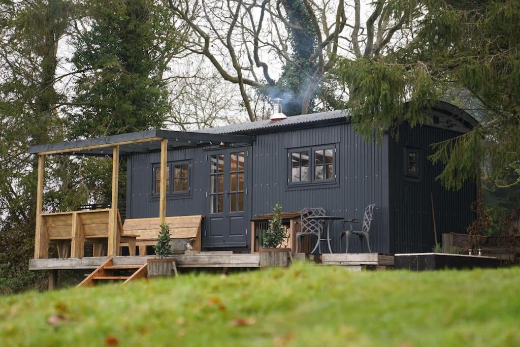 布里斯托Shepherds Hut in countryside near Bath and Bristol的草坪上门廊的蓝色小房子