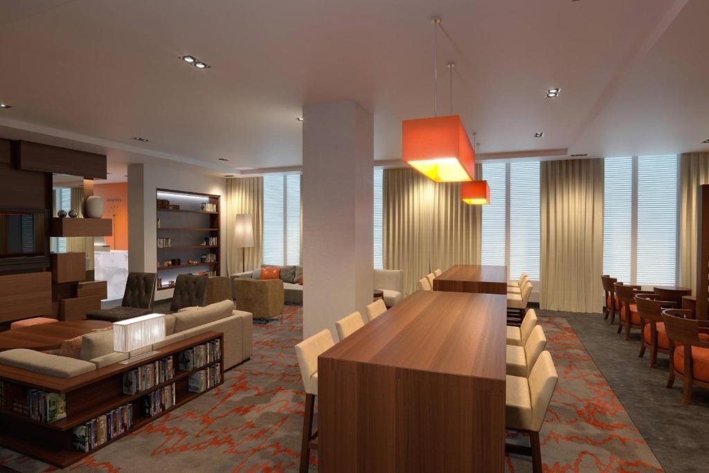 纽约纽约曼哈顿/世界贸易中心区万豪原住客栈酒店的一个带长木桌子和椅子的图书馆
