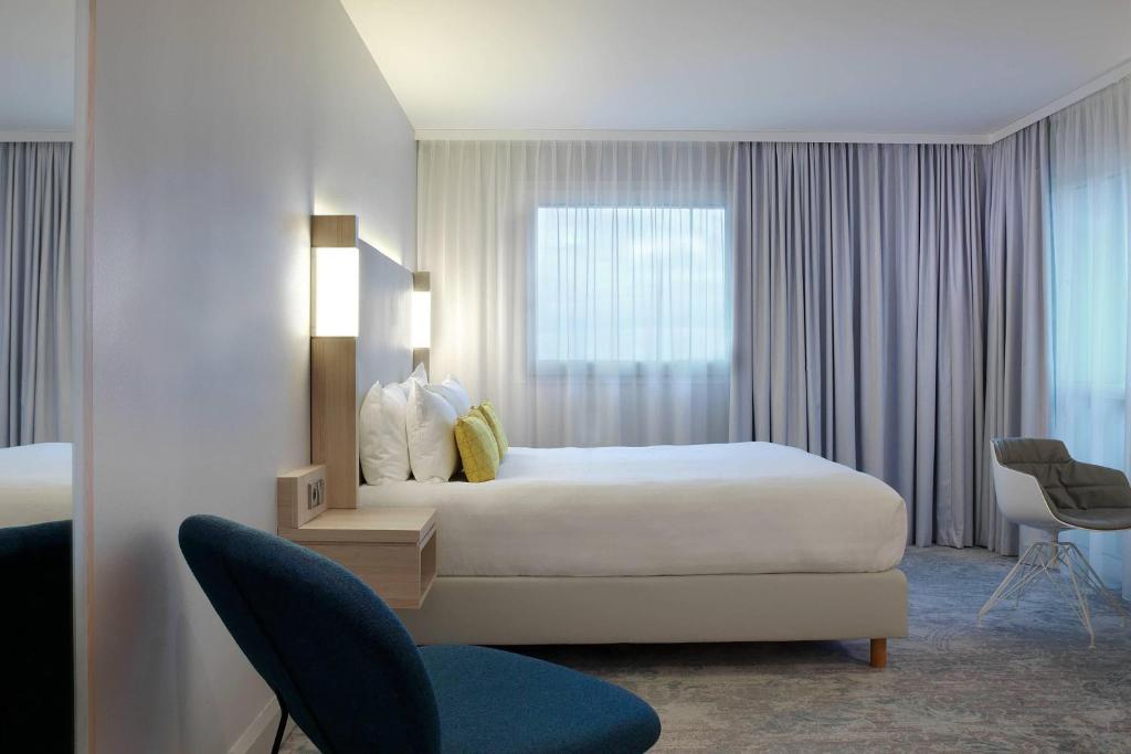 勒梅尼尔阿姆洛The Jangle Hotel - Paris - Charles de Gaulle - Airport的酒店客房设有床和窗户。