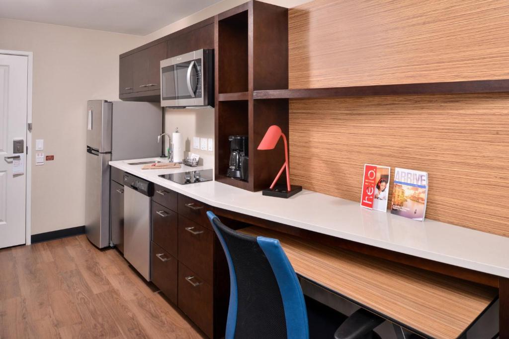 奇诺岗TownePlace Suites by Marriott Ontario Chino Hills的厨房配有柜台、书桌和冰箱。