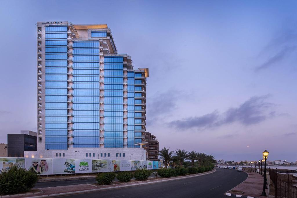 吉达Four Points by Sheraton Jeddah Corniche的道路一侧高大的建筑