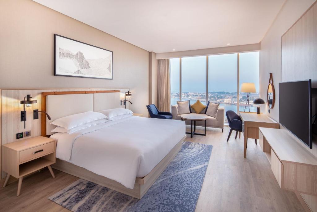 吉达Four Points by Sheraton Jeddah Corniche的酒店客房,配有一张床、一张桌子和椅子