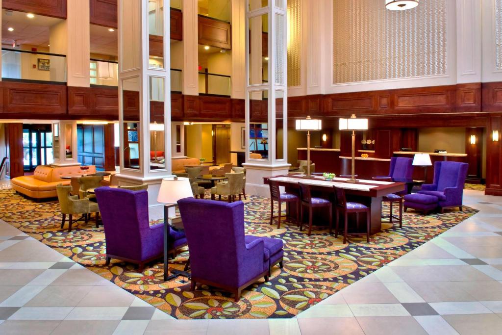 斯坦福德斯坦福万豪水疗酒店的大堂设有紫色椅子和桌子,铺在地毯上