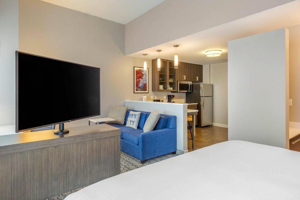 普罗维登斯Residence Inn Providence Downtown的客厅配有大电视和蓝色沙发