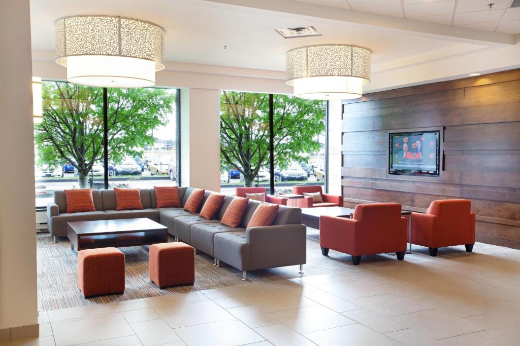 萨格奈沙格奈河三角洲 - 会议中心酒店的大堂配有沙发、椅子和窗户。