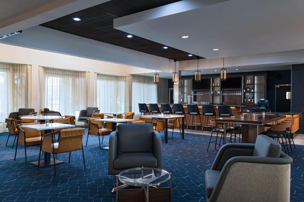 圣安东尼奥万怡酒店圣安东尼奥机场的一间带桌椅的餐厅和一间酒吧