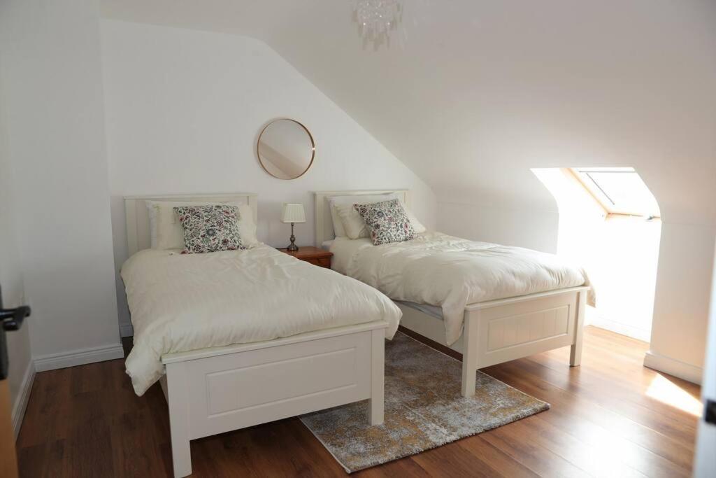 基利赫维林4 Castle Court的一间卧室设有两张床,墙上设有一面镜子