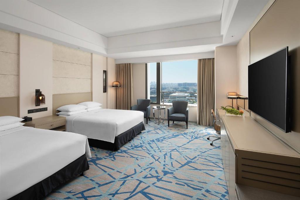 上海上海漕河泾万丽酒店的酒店客房设有两张床和一台平面电视。