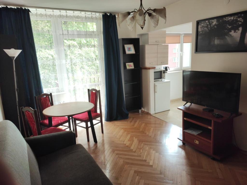 华沙Zielony Żoliborz的客厅配有电视和桌椅