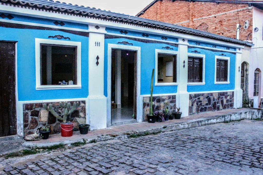 伦索伊斯Buena Vibe Hostel的鹅卵石街道上的一座蓝色和白色的建筑