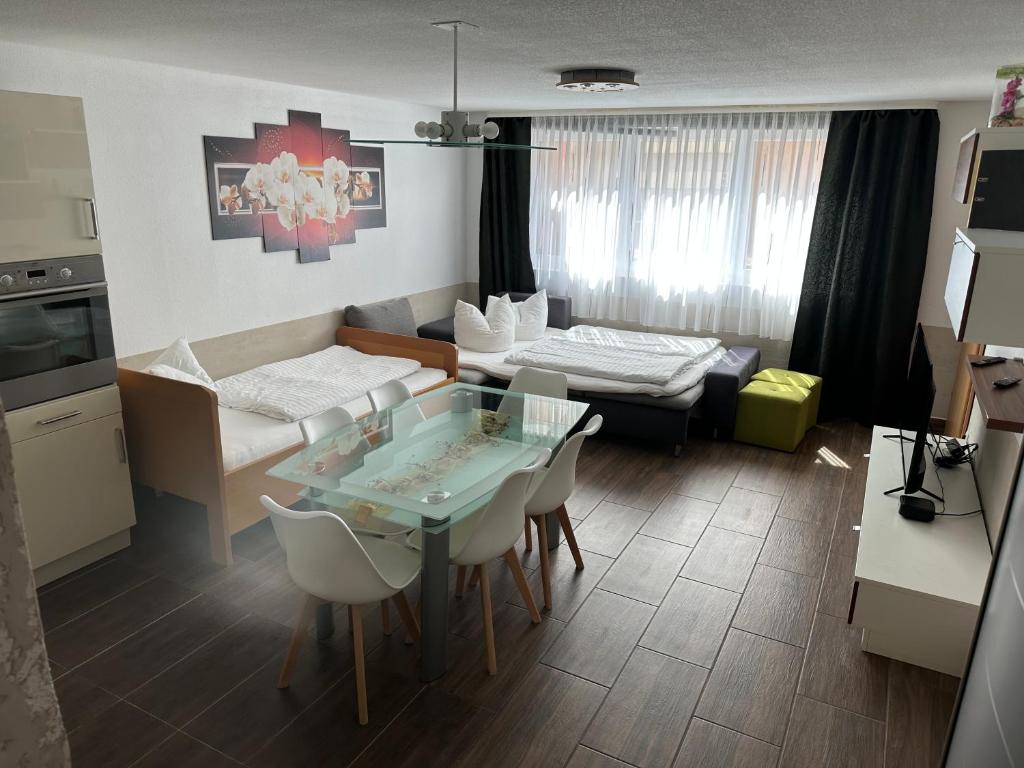 基彭海姆Apartment Stabel 8,1 km von Europa Park的厨房以及带桌椅的起居室。