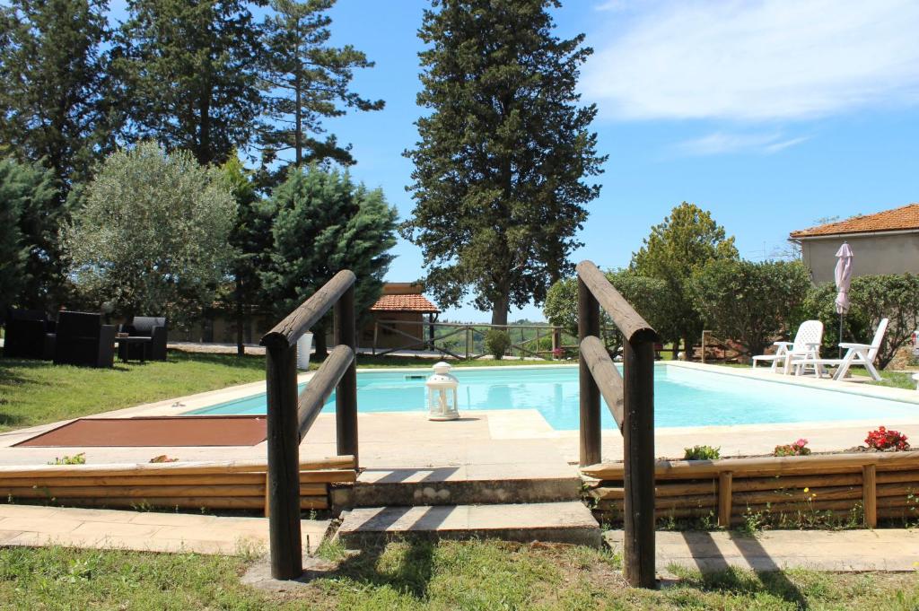 圣焦万尼达索Casa vacanza Podere Ristoro的游泳池旁设有两个木栏杆