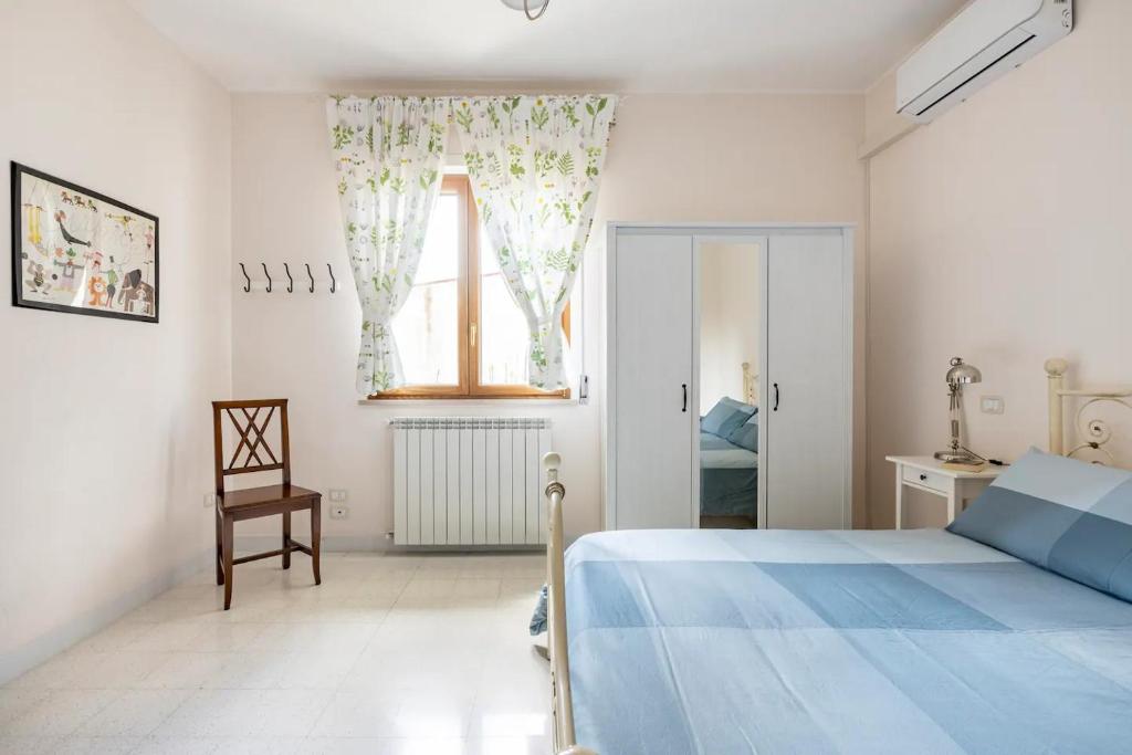 GrassanoB&B Vigna del Duca的白色卧室设有蓝色的床和窗户