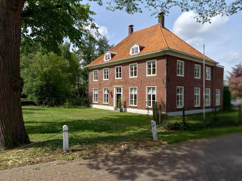 博克斯梅尔B&B Huize Placida的前面有一棵树的大型红砖房子
