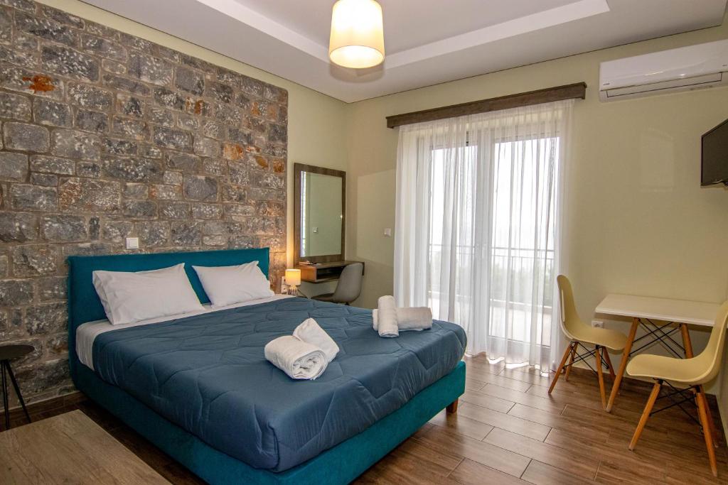 卡拉马塔Verga's Apartments的一间卧室设有蓝色的床和砖墙