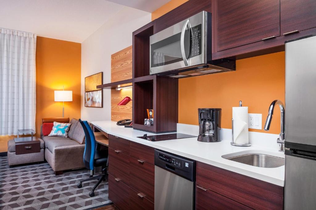 奥兰多TownePlace Suites by Marriott Orlando Altamonte Springs/Maitland的一个带水槽的厨房和一间客厅