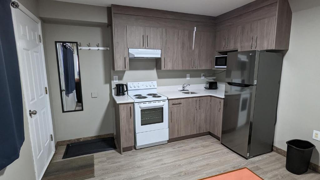 梅迪辛哈特Riverside Motel的厨房配有白色家电和木制橱柜