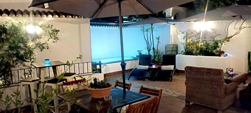 伊斯纳哈尔Casa Las Tinajas的庭院配有桌椅和遮阳伞。