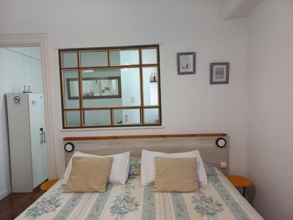 布宜诺斯艾利斯Acogedor apartamento céntrico. Obelisco.的卧室配有一张壁挂镜子的床
