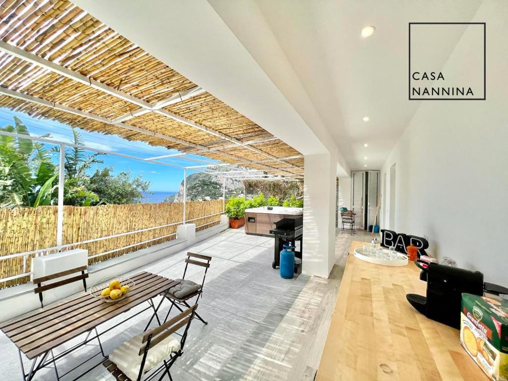 卡普里Casa Nannina - Seaview Terrace with Jacuzzi in Capri的客厅设有带桌子和钢琴的庭院。