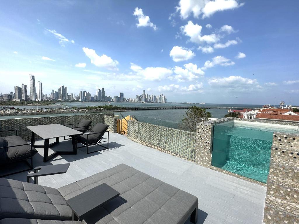 巴拿马城AmazINN Places Penthouse Deluxe, Skyline and Private Rooftop的一个带桌椅的庭院和一个游泳池