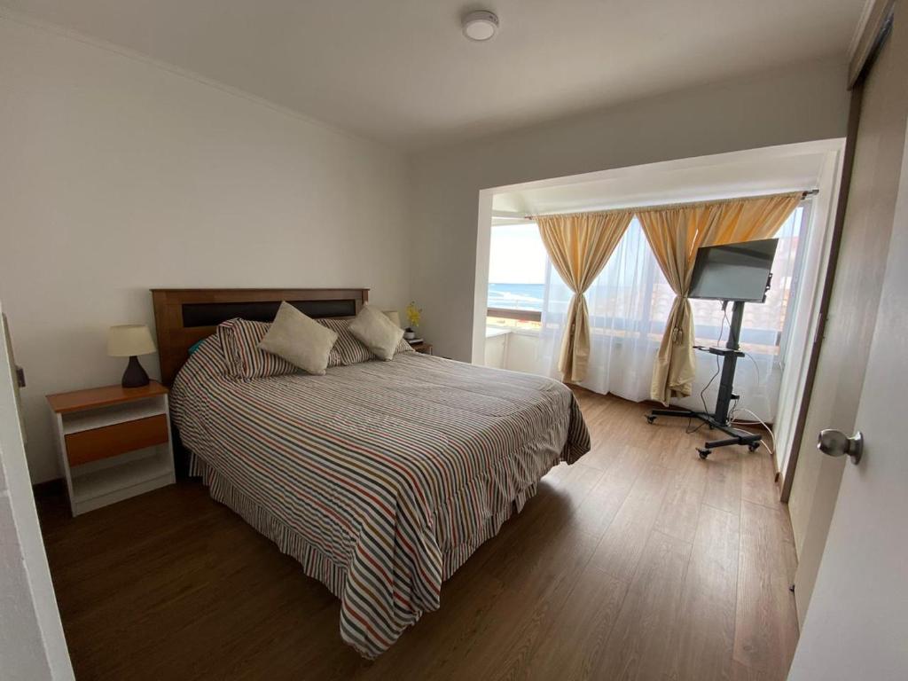 维纳德马Departamento con vista al mar的一间卧室设有一张床和一个大窗户