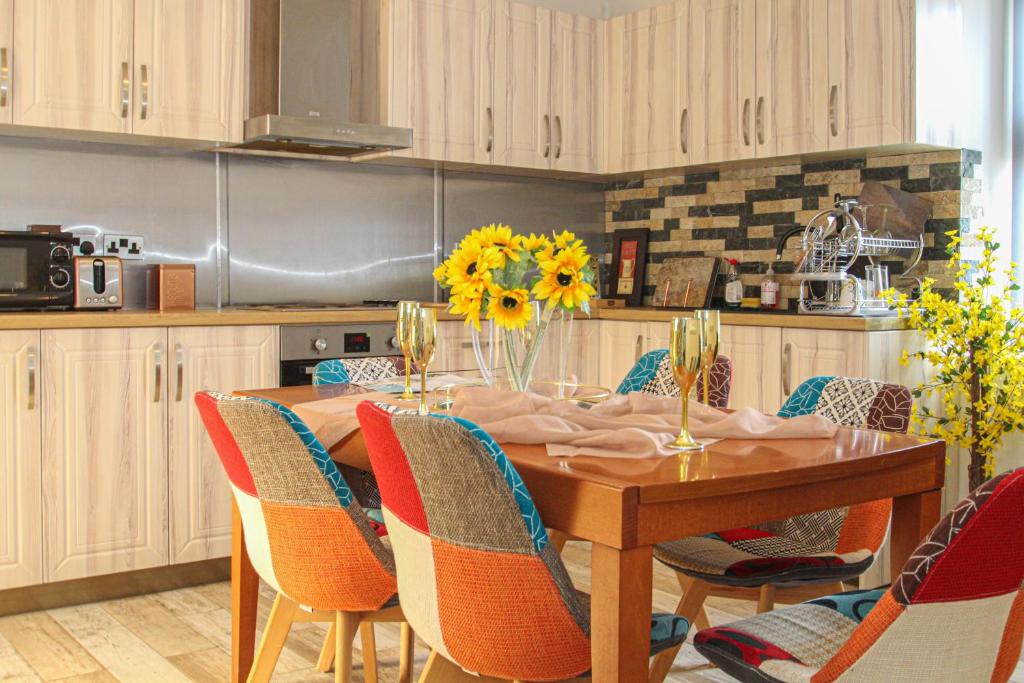 拉纳克Deluxe Apartment的厨房配有带椅子的木桌