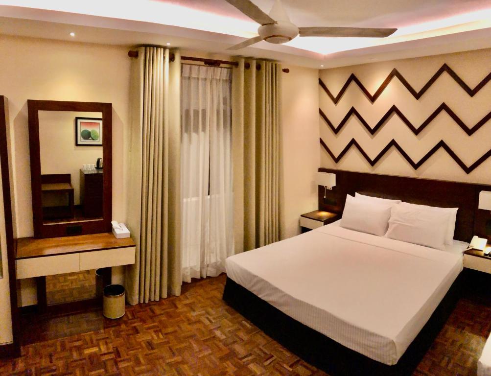 WatumullaTropic Inn - Mount Lavinia的卧室配有一张白色大床和镜子