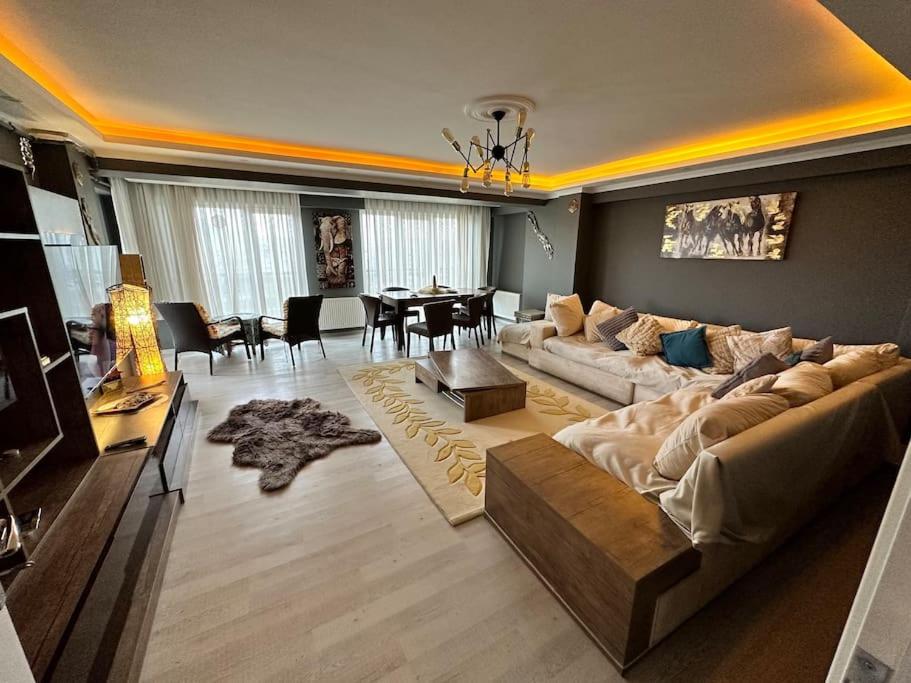 恰纳卡莱Akhome - Luxury dublex apartment的一间带大沙发的客厅和一间餐厅