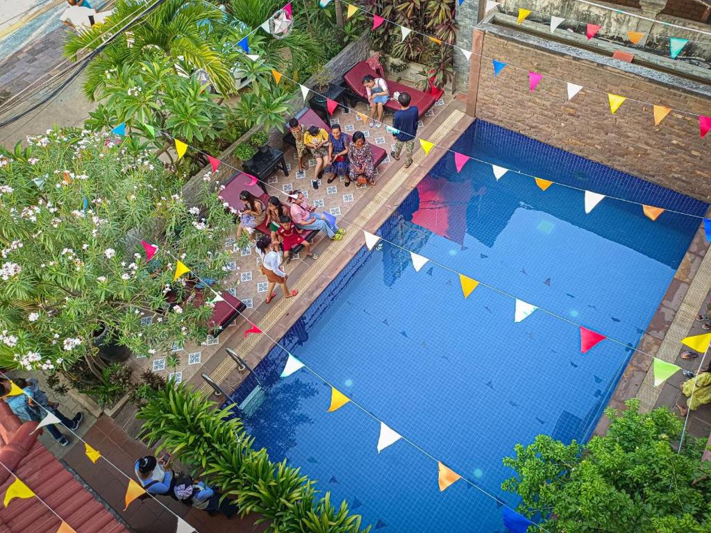 暹粒Jasmine Lodge Siem Reap的享有带旗帜和人员的游泳池的顶部景致