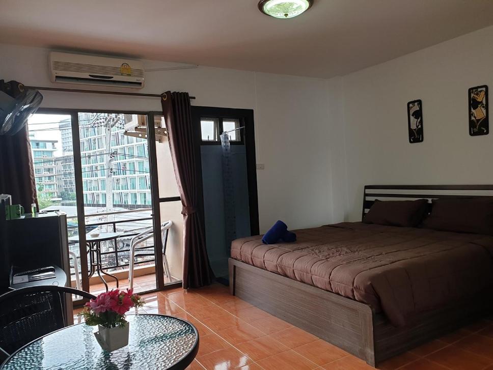 芭堤雅市中心Secrets - Pattaya的一间卧室配有一张床和一张玻璃桌