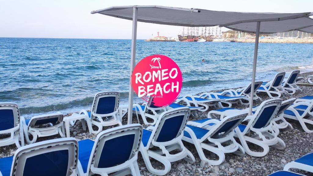 凯麦尔罗密欧海滩酒店 的海滩上的一组椅子和一把遮阳伞