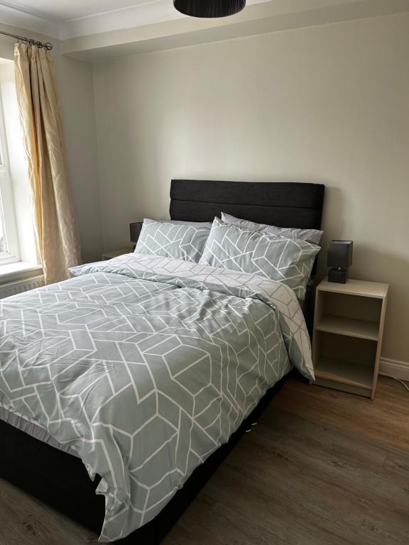 IfordPrivate room in family home的卧室配有一张带灰色和白色棉被的床