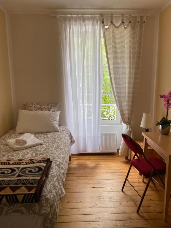 迪纳尔VILLA LA VISTULE的一间卧室配有一张床、一张书桌和一个窗户。