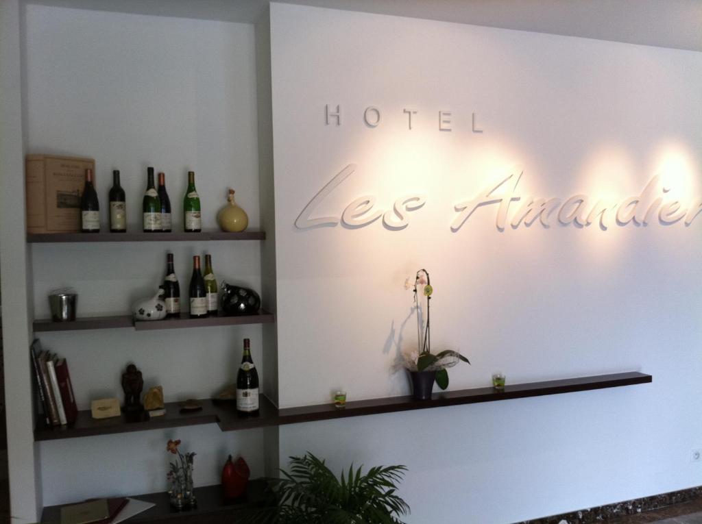 罗纳河畔的图尔农Hotel Les Amandiers的墙上装有葡萄酒的房间