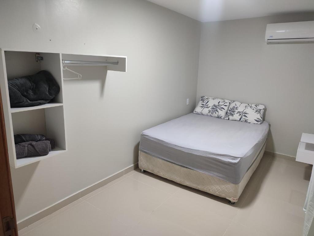 博阿维斯塔JR Casa Contêiners的一间小卧室,在白色的房间里配有一张床