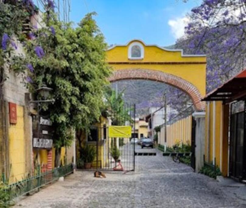 危地马拉安地瓜Casa la Ermita的街道上一座黄色的建筑,有拱门