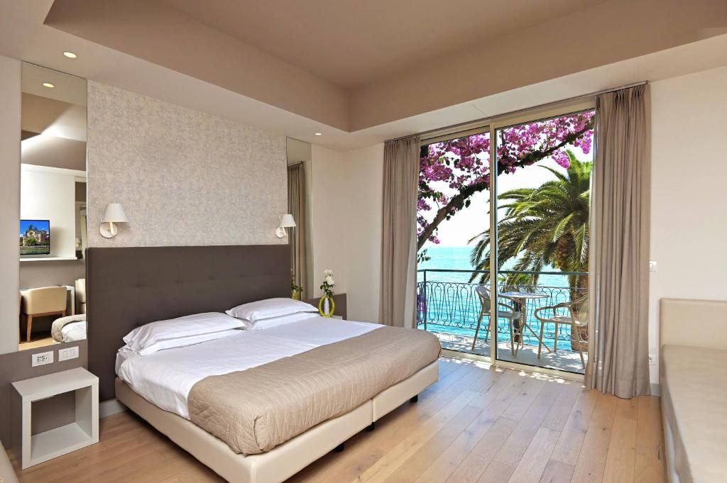 加尔多内-里维耶拉Hotel Monte Baldo e Villa Acquarone的一间卧室设有一张大床和一个大窗户