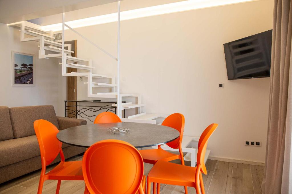 滨海阿热莱斯Résidence du Lido的一间带桌子和橙色椅子的用餐室