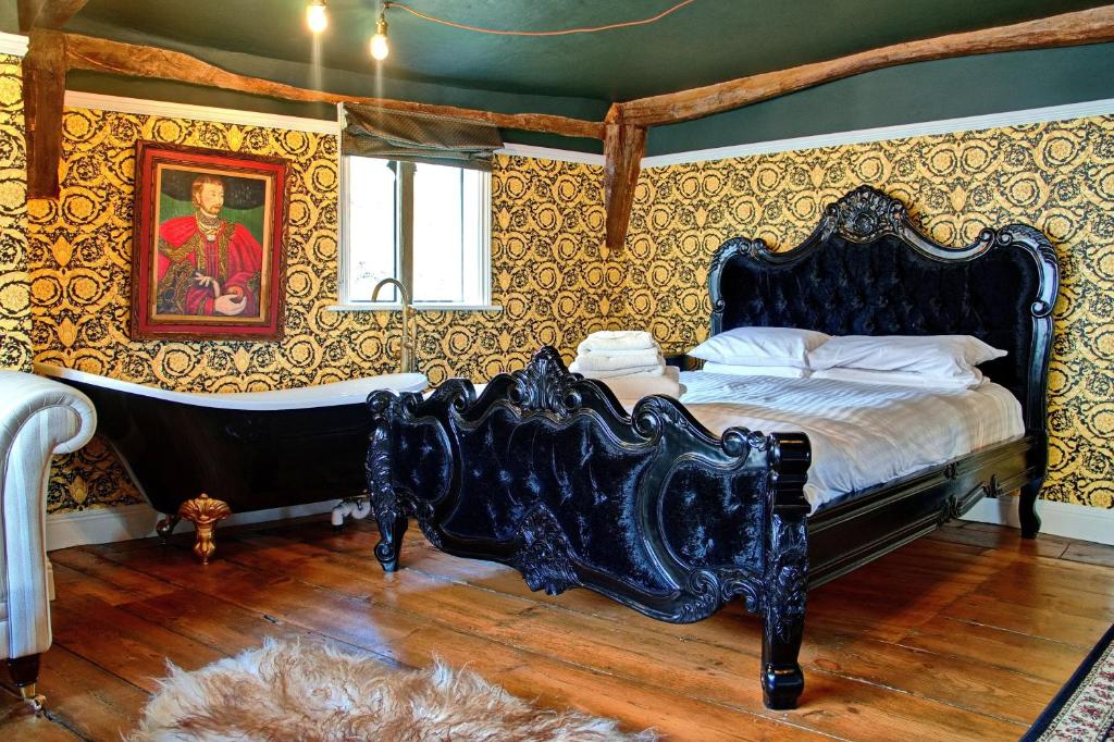 萨弗伦沃尔登Huge & Deluxe 600 Year Old Essex Manor House的一间卧室配有一张床和一个浴缸