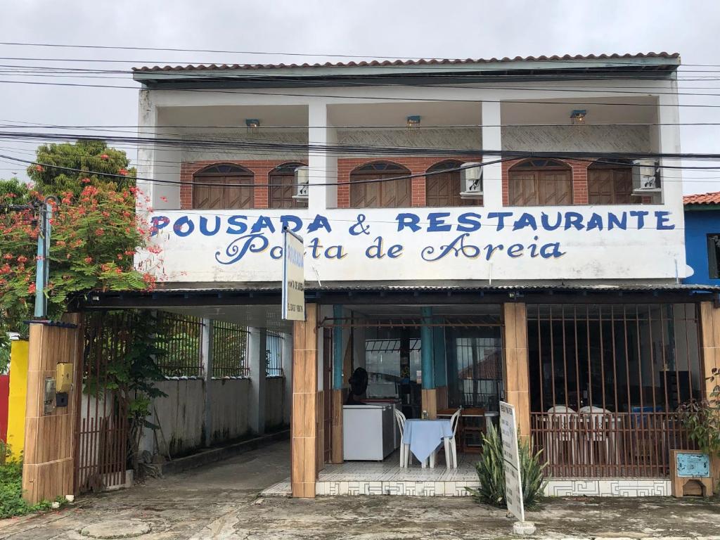 伊塔帕里卡Pousada Ponta de Areia的大楼前有标志的餐厅
