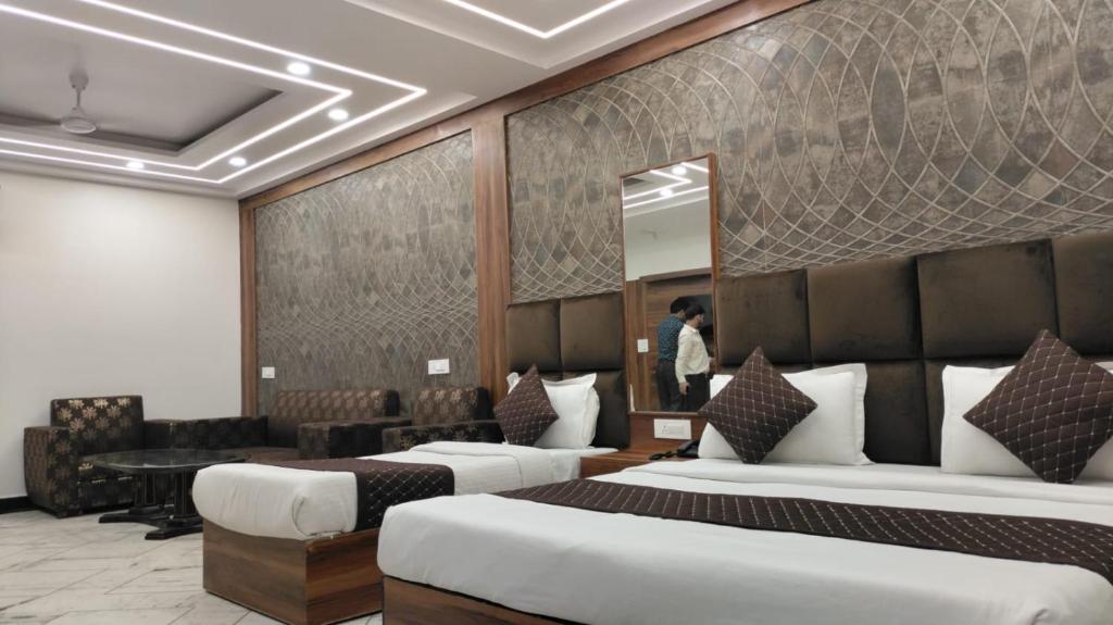 新德里HOTEL SINGH CONTINETAL的酒店客房,设有两张床和镜子